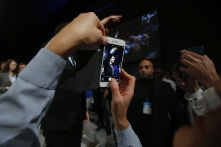 FILE PHOTO - A supporter of former French economy minister Emmanuel Macron uses a mobile phone at a political rally for his political movement, En Marche !, or Forward !, in Le Mans, France, October 11, 2016. REUTERS/Stephane Mahe