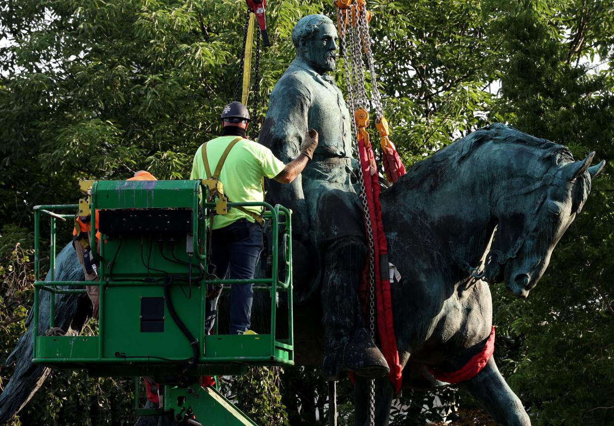 Workers remove a statue of Confederate General Robert E. Lee from Market Street Park July 10, 2021 in Charlottesville, Virginia.