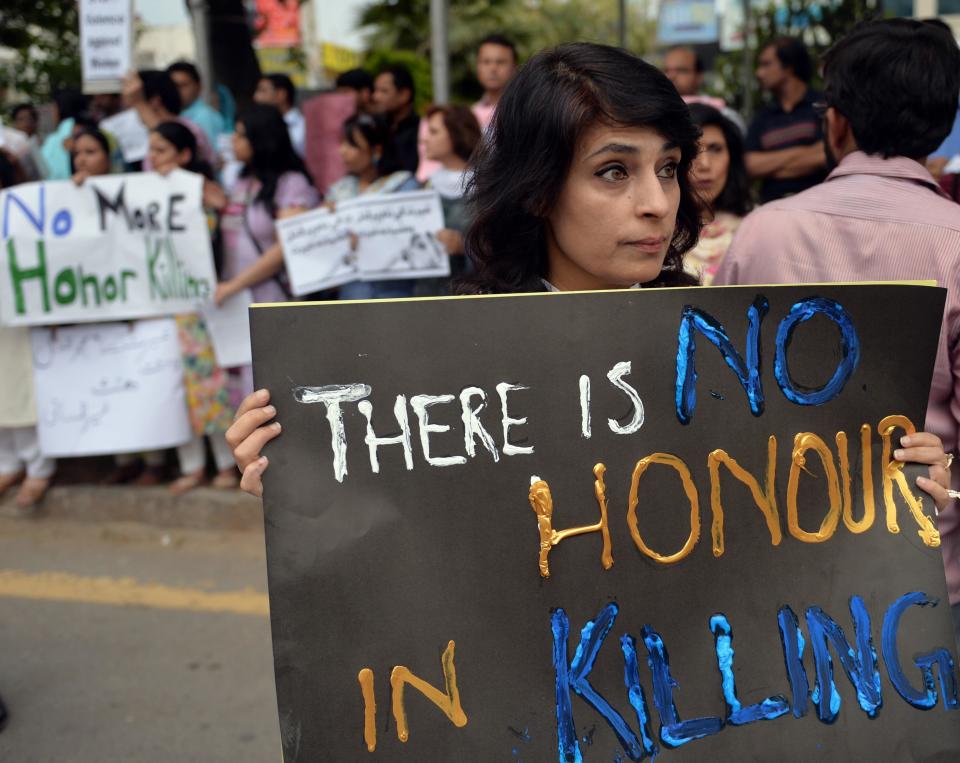 Pakistani human rights activists hold placards during a protest in Islamabad on May 29, 2014 against the killing of a pregnant woman who was beaten to death with bricks by members of her own family for marrying a man of her own choice in Lahore.  / Credit: AAMIR QURESHI/AFP via Getty Images