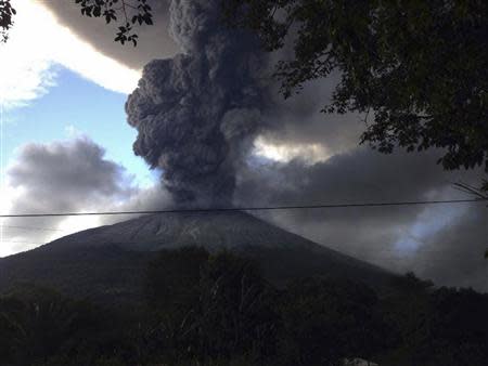 The Chaparrastique volcano, behind electricity cables, spews ash at the municipality of San Miguel December 29, 2013. REUTERS/Stringer