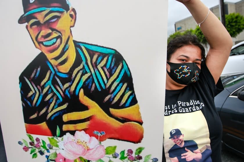 GARDENA, CA - JUNE 28: Jennifer Guardado, sister of Andres Guardado, who was fatally shot by a sheriff's deputy in Gardena, holds a sign of her brother at the rally seeking justice for Andres Guardado on Sunday, June 28, 2020 in Gardena, CA. (Jason Armond / Los Angeles Times)