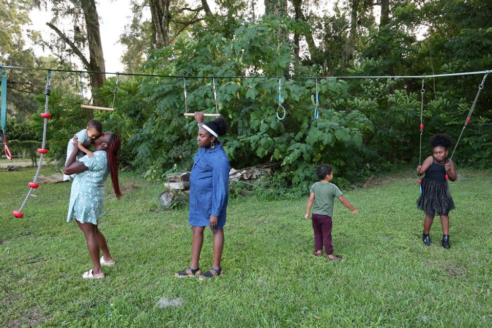 Jasmine Brown plays with her kids in the backyard of their home in Marion County, Fla., Thursday, Oct. 5, 2023.