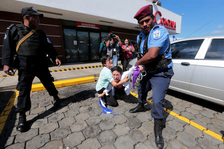 Riot police try to detain a protester during a march called " United for freedom" against Nicaraguan President Daniel Ortega's in Managua, Nicaragua October 14, 2018. REUTERS/Oswaldo Rivas