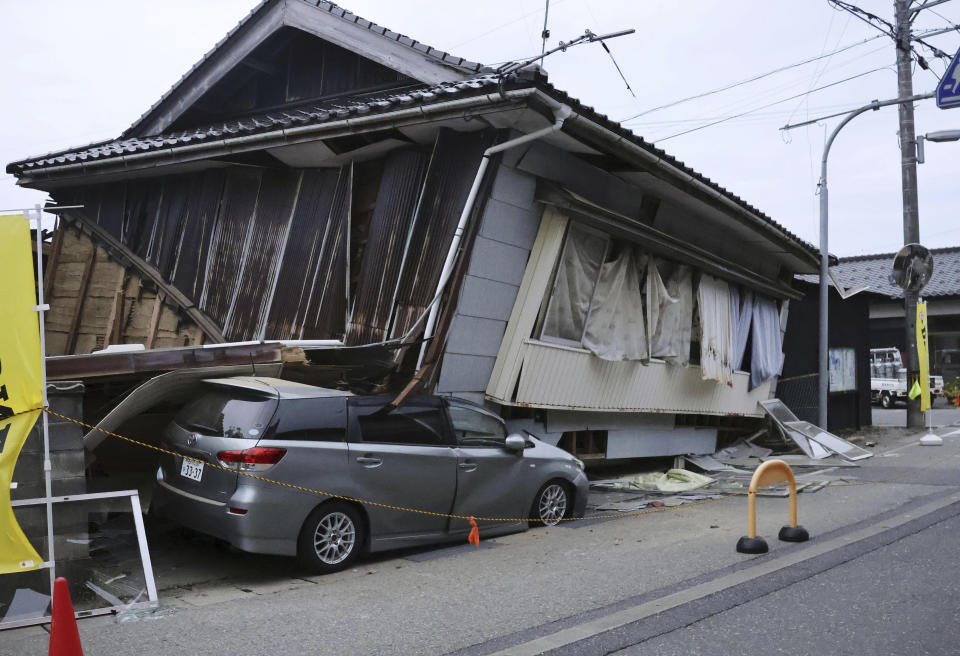 A car is seen crushed by a collapsed house after a strong earthquake in Suzu city, Ishikawa prefecture, northern Japan, Friday, May 5, 2023. A strong earthquake hit Friday afternoon near central Japan, but there were no reports of a tsunami threat.(Kyodo News via AP)