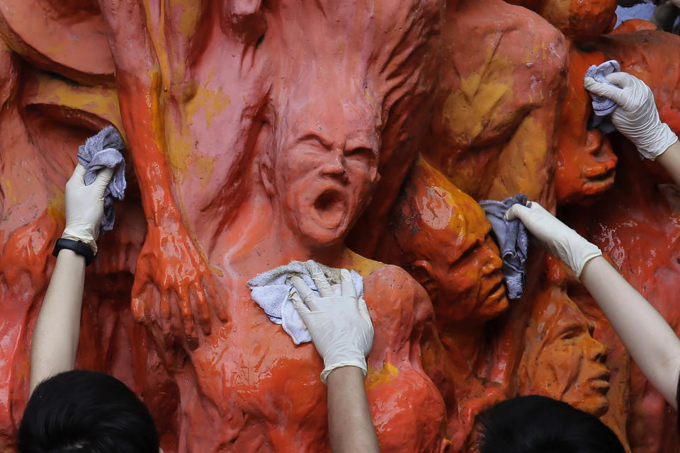 FILE - In this June 4, 2019, file photo, university students clean the "Pillar of Shame" statue, a memorial for those killed in the 1989 Tiananmen crackdown, at the University of Hong Kong. Danish artist Jens Galschioet is seeking to get back his sculpture in Hong Kong memorializing the victims of China's 1989 Tiananmen Square crackdown as a deadline loomed for its removal Wednesday, Oct. 13, 2021. (AP Photo/Kin Cheung, File)