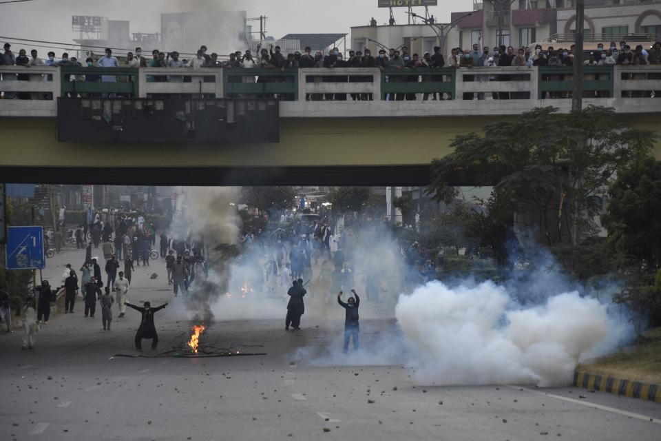 Police fire tear gas shell to disperse supporters of former Pakistani Prime Minister Imran Khan's party, 'Pakistan Tehreek-e-Insaf' during a protest to condemn a shooting incident on their leader's convoy, in Rawalpindi, Pakistan, Friday, Nov. 4, 2022. Khan who narrowly escaped an assassination attempt on his life the previous day when a gunman fired multiple shots and wounded him in the leg during a protest rally is listed in stable condition after undergoing surgery at a hospital, a senior leader from his party said Friday. (AP Photo/W.K. Yousafzai)