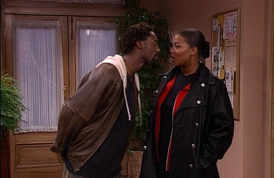 Isaiah Washington leaning in to kiss Queen Latifah in a scene from "Living Single"