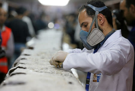 An Egyptian scientist works on restoring a piece of the second Khufu boat at a temporary laboratory set up next to the Great Pyramids where it was discovered, in Giza, Egypt March 29, 2017. REUTERS/Mohamed Abd El Ghany