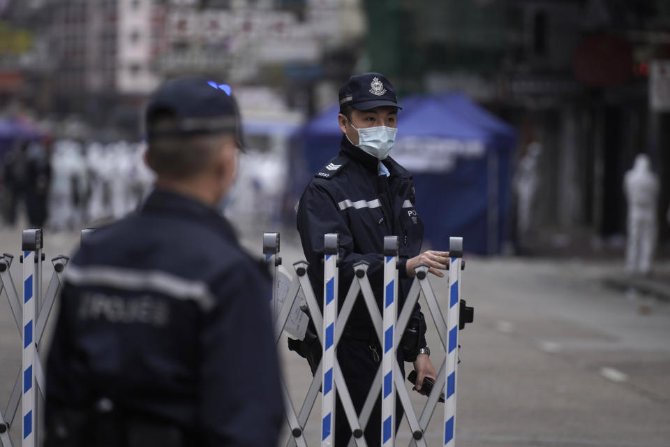 Police officers stand guard at the closed area in Jordan district, in Hong Kong, Sunday, Jan. 24, 2021. Thousands of Hong Kong residents were locked down Saturday in an unprecedented move to contain a worsening outbreak in the city, authorities said. (AP Photo/Vincent Yu)