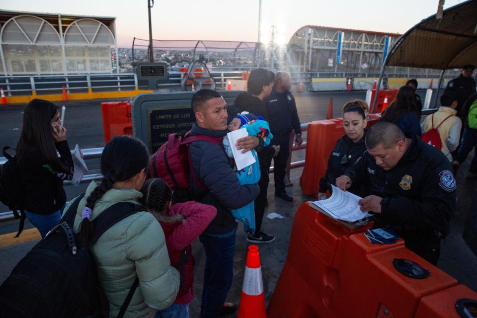 Customs and Border Protection officers check a list at the Paso Del Norte International Bridge as they process migrants who had received an appointment via the CPB One on Dec. 14, 2023.