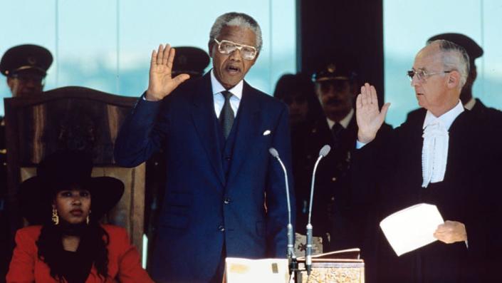 Nelson Mandela raises his hand to take the oath of office at his inauguration as President of South Africa