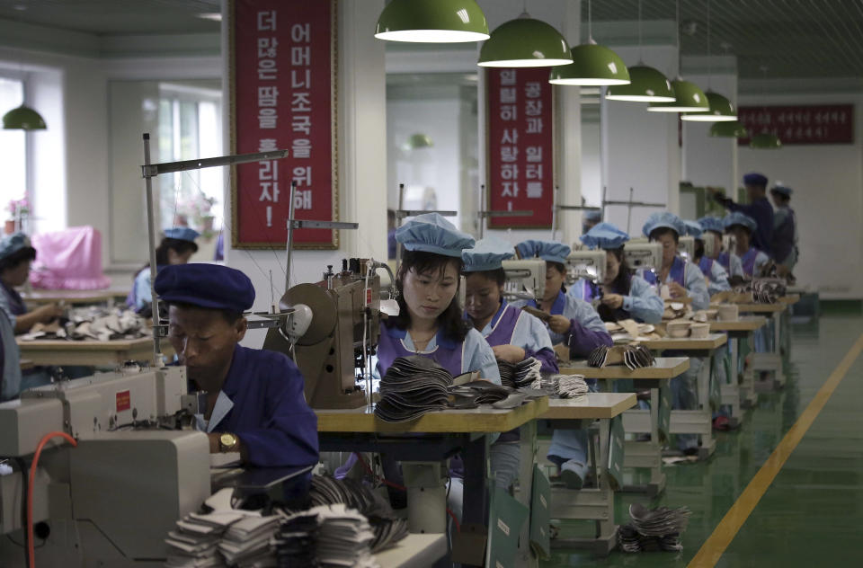 FILE - In this June 22, 2016, file photo, factory workers operate sewing machines at a shoe factory in Wonsan, North Korea. Two months after he failed to win a badly needed easing of sanctions from U.S. President Donald Trump, North Korean leader Kim Jong Un is traveling to Russia in a possible attempt to win its help as the U.S.-led trade sanctions hurt his country’s already-struggling economy. (AP Photo/Wong Maye-E, File)