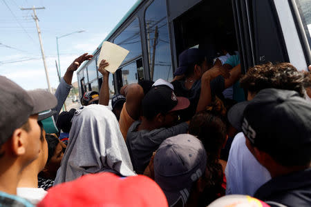 A group of Central American migrants, moving in a caravan through Mexico, get on a microbus to get to the office of Mexico's National Institute of Migration to start the legal process and get temporary residence status for humanitarian reasons, in Hermosillo, Sonora state, Mexico April 24, 2018. REUTERS/Edgard Garrido