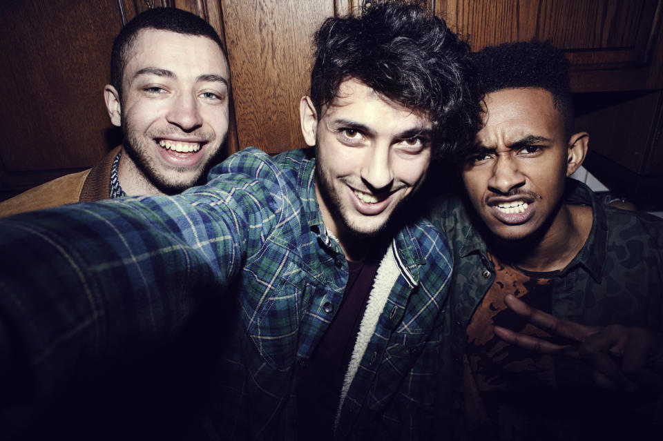 Three friends taking a close-up selfie, smiling and making faces