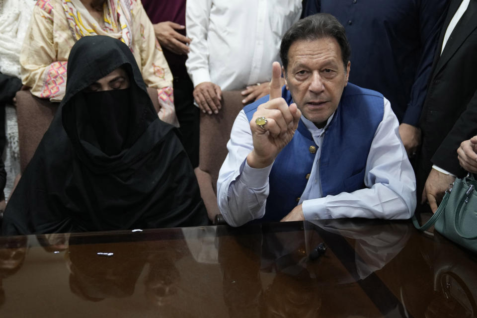 FILE - Pakistan's former Prime Minister Imran Khan, right, and Bushra Bibi,his wife, speak to the media before signing documents to submit surety bond over his bails in different cases, at an office of Lahore High Court in Lahore, Pakistan, on July 17, 2023. A Pakistani court on Saturday, Feb. 3, 2024 convicted and sentenced imprisoned former Prime Minister Imran Khan and his wife Bushra Bibi to five years in prison each on a charge that their 2018 marriage violated the legal requirement that a woman wait three months before remarriage, officials and a defense lawyer said. (AP Photo/K.M. Chaudary, File))