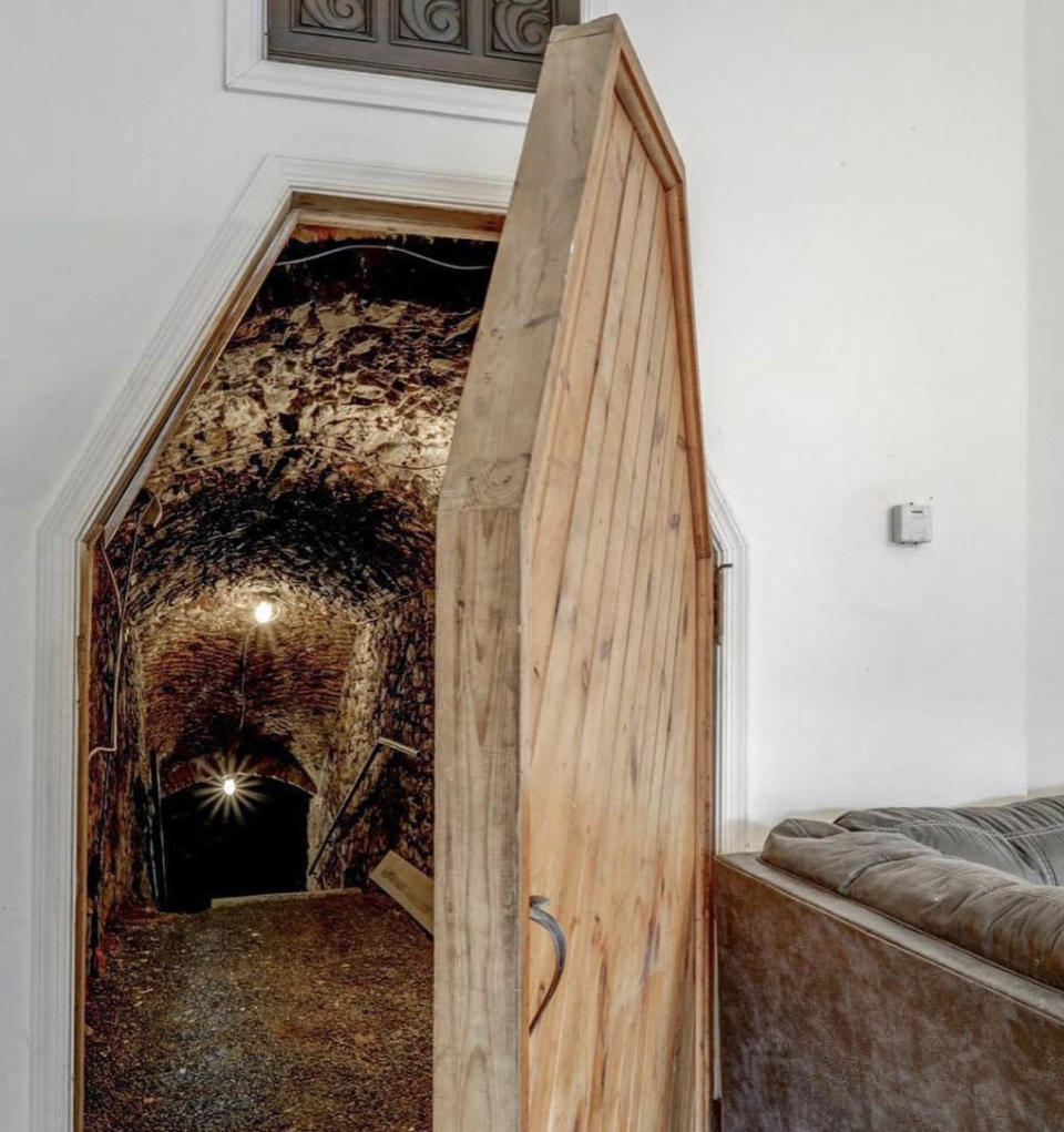 Wooden door in living room opening up to a cave.