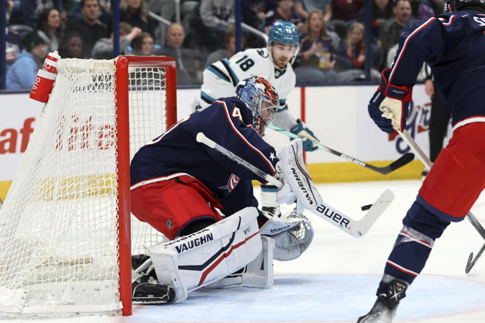 Columbus Blue Jackets goalie Daniil Tarasov, left, makes a stop in front of San Jose Sharks forward Filip Zadina during the first period of an NHL hockey game in Columbus, Ohio, Saturday, March 16, 2024. (AP Photo/Paul Vernon)