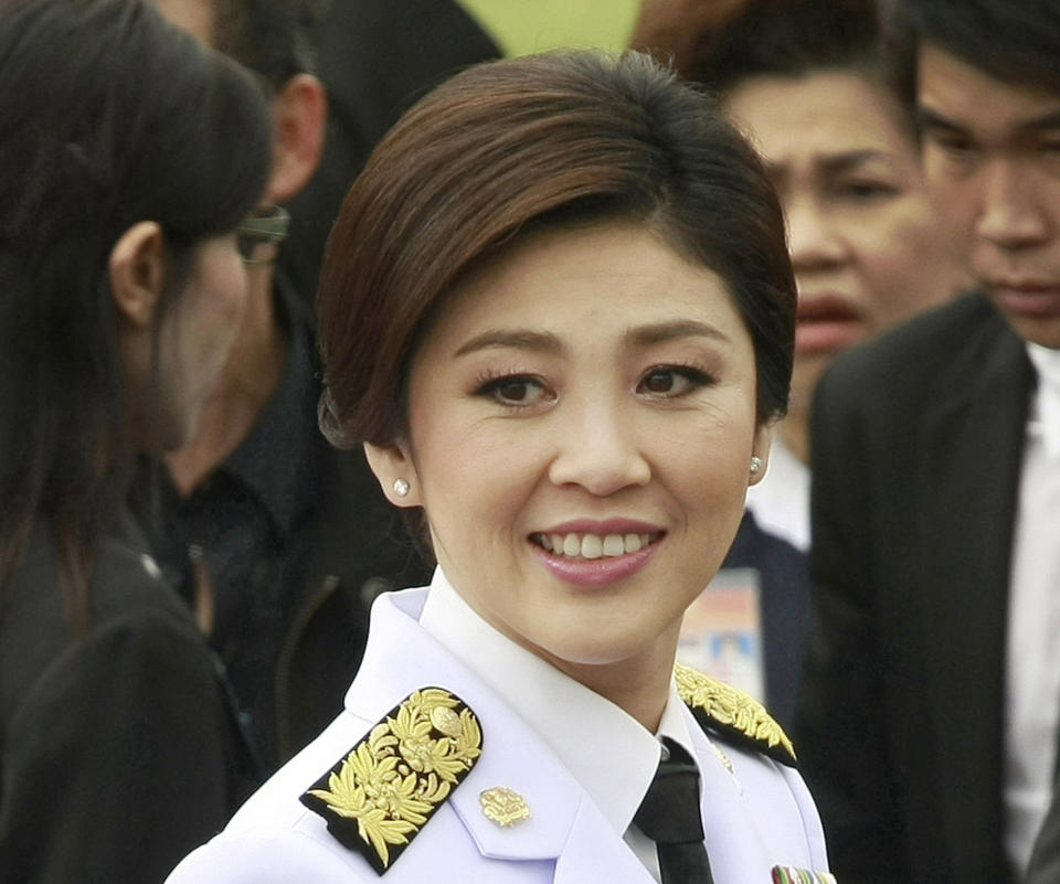 In this photo taken Aug. 10, 2011, Thai Prime Minister Yingluck Shinawatra smiles after a group photo with her cabinet members following an oath taking ceremony at the government house in Bangkok, Thailand. As she marks a year in office as Thailand's first female prime minister, Yingluck's biggest boast could be about what she hasn't brought to Thai politics, a return to the chaos that has wracked the country for much of the past six years. (AP PhotoApichart Weerawong)