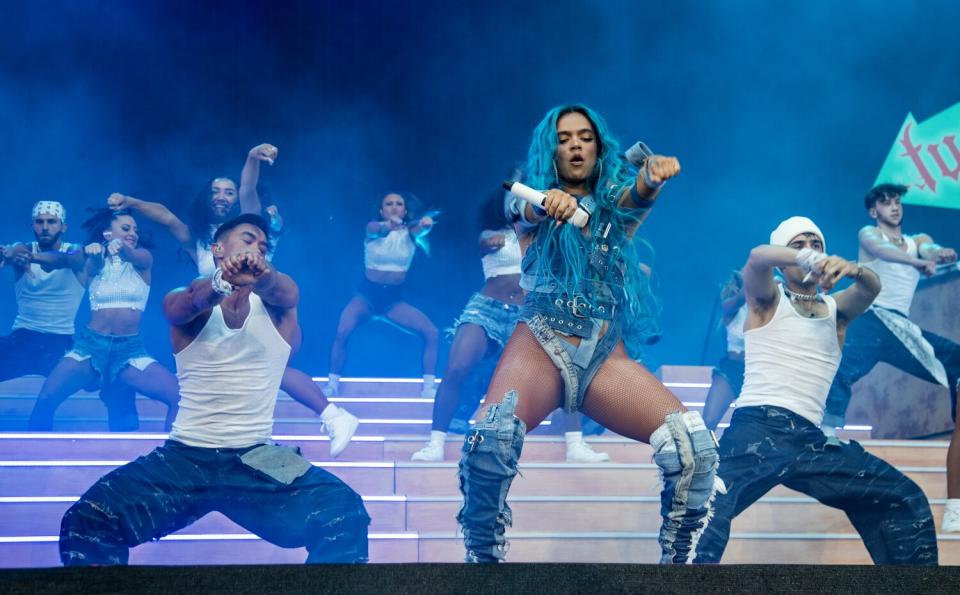 With her bright blue hair, Karol G performs with two dancers on Coachella's main stage.