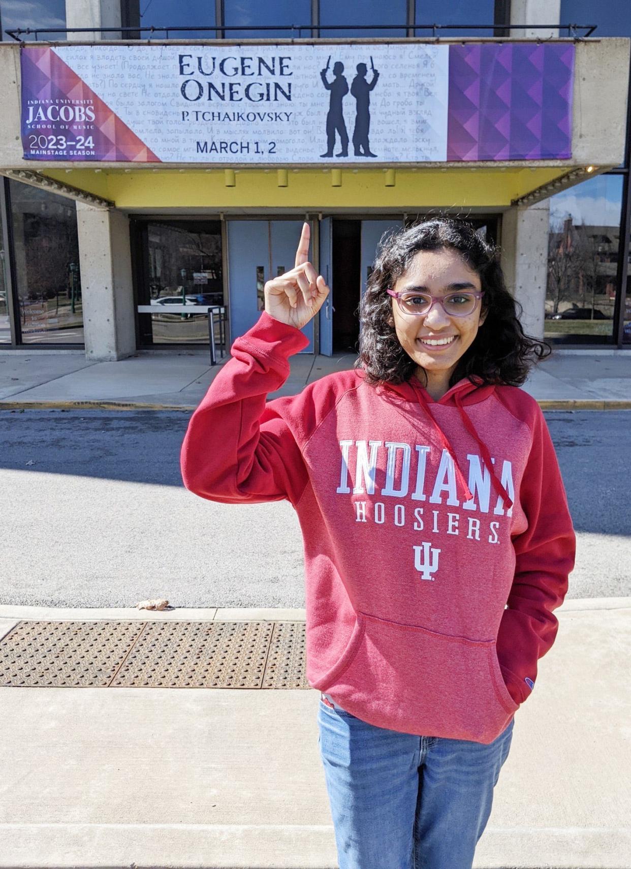 Tiara Abraham points to the sign announcing the performance of Eugene Onegin by the Jacobs School of Music. She was one of the Indiana University students in the opera.