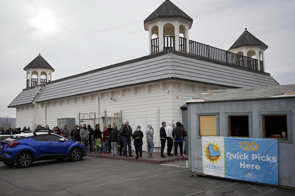 People wait in line at the Lotto Store at Primm just inside the California border Friday, Jan. 13, 2023, near Primm, Nev. Mega Millions players will have another chance Friday night to end months of losing and finally win a jackpot that has grown to $1.35 billion. (AP Photo/John Locher)