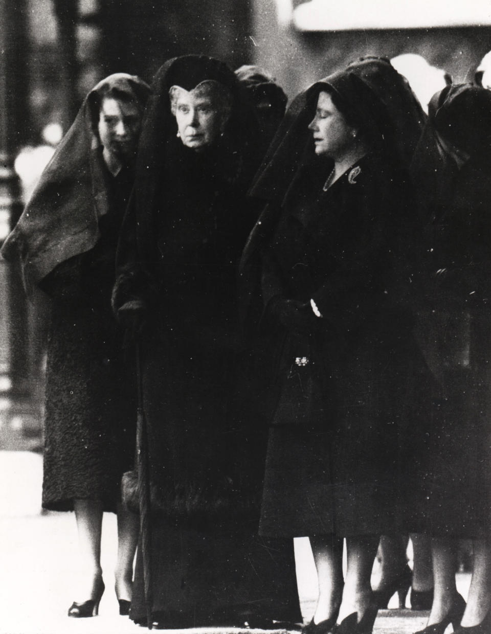 FILE - In this Feb. 11, 1952 file photo, Britain's Queen Elizabeth II, left, stands with her grandmother Queen Mary, center, and her mother, Queen Elizabeth, at the entrance to London's Westminster Hall as her father's coffin arrives to lie in state. Hundreds of thousands of people are expected to flock to London’s medieval Westminster Hall from Wednesday, Sept. 14, 2022, to pay their respects to Queen Elizabeth II, whose coffin will lie in state for four days until her funeral on Monday. (AP Photo/Ron Case, File)