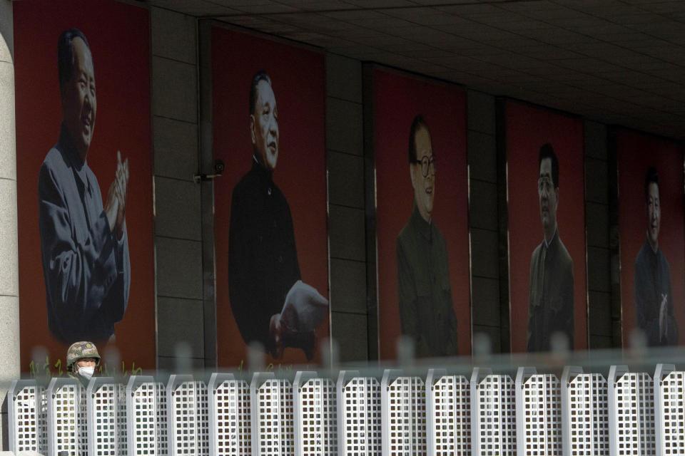 A soldier stands guard near portraits of China's top leaders from Mao Zedong at left to current Chinese President Xi Jinping at right in Beijing, Tuesday, Oct. 11, 2022. For decades, Chinese journalist Ho Pin has made accurate predictions about who would ascend into the ranks of China's leadership. But this year, just weeks before Beijing reveals its next generation of leaders, Ho says there's little point. He says Xi has consolidated power to such a degree that no matter who is promoted, they will all have to obey Xi's rule. (AP Photo/Ng Han Guan)