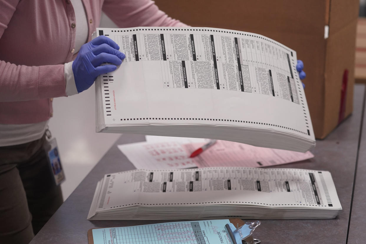 An election worker gathers tabulated ballots to be boxed inside the Maricopa County Recorders Office, Thursday, Nov. 10, 2022, in Phoenix. (AP Photo/Matt York)