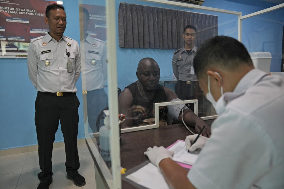 Officers check the health condition of a Nigerian detainee at Tanjungpinang Central Immigration Detention Center on Bintan Island, Indonesia, Wednesday, May 15, 2024. This three-story detention facility, with its barred windows and fading paint, is home to dozens of detainees facing uncertain futures, including whether they will ever return to their homelands, in conditions that closely resemble a prison. (AP Photo/Dita Alangkara)