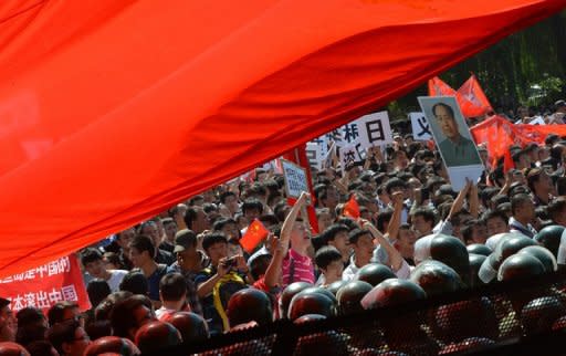 Demonstrators surge towards police lines during a large-scale anti-Japanese protest outside the Japanese Embassy in Beijing on September 15. Shares in Japan Airlines slumped 4.29 percent Friday, two days after relisting, as it said it would slash flights to China amid a territorial row over a group of islands between Tokyo and Beijing