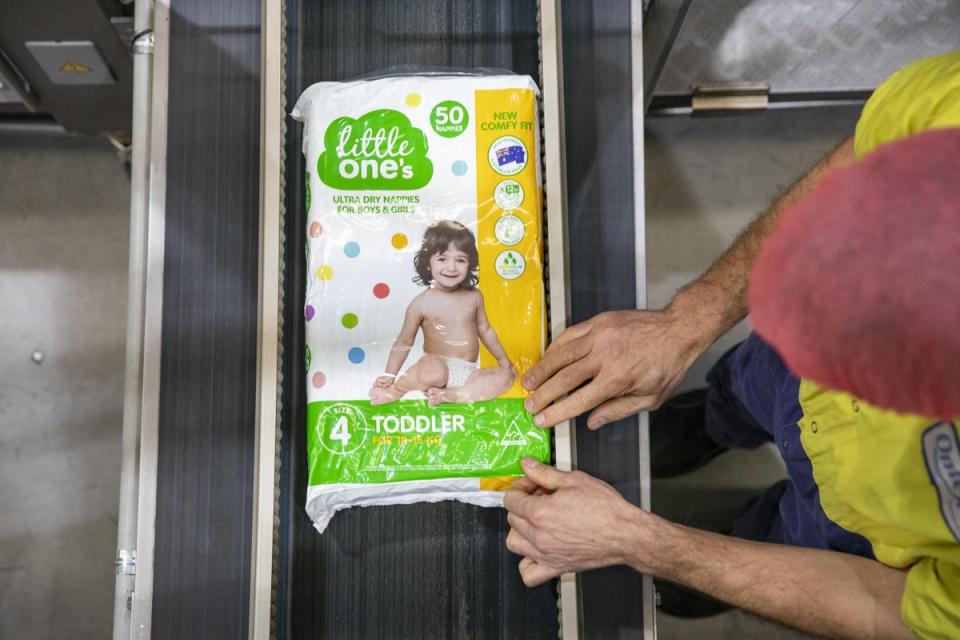 Woolworths Little One's nappies are pictured on a conveyor belt.