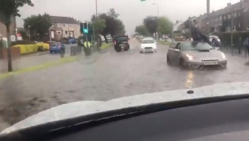 Video grab of a man sat on the roof of his car after becoming stranded following flash flooding in Edinburgh.