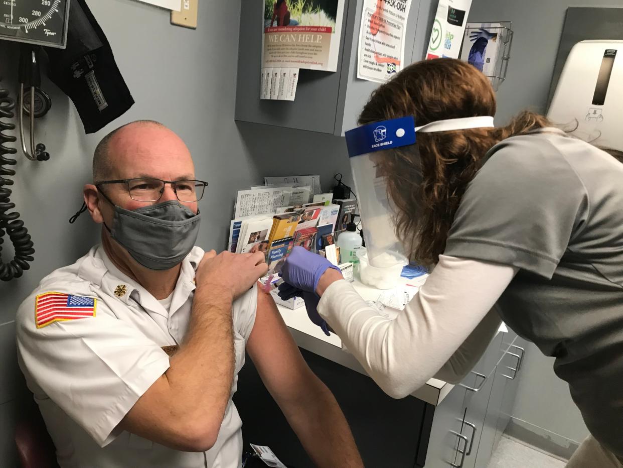 Deb Agee, Sandusky County Public Health's director of nursing, gives a vaccination shot to Sandusky County EMS Director Jeff Jackson at the health department's Fremont office in December 2020. The Countryside Drive office will offer limited services Monday, a week after bursting water pipes caused significant water damage.