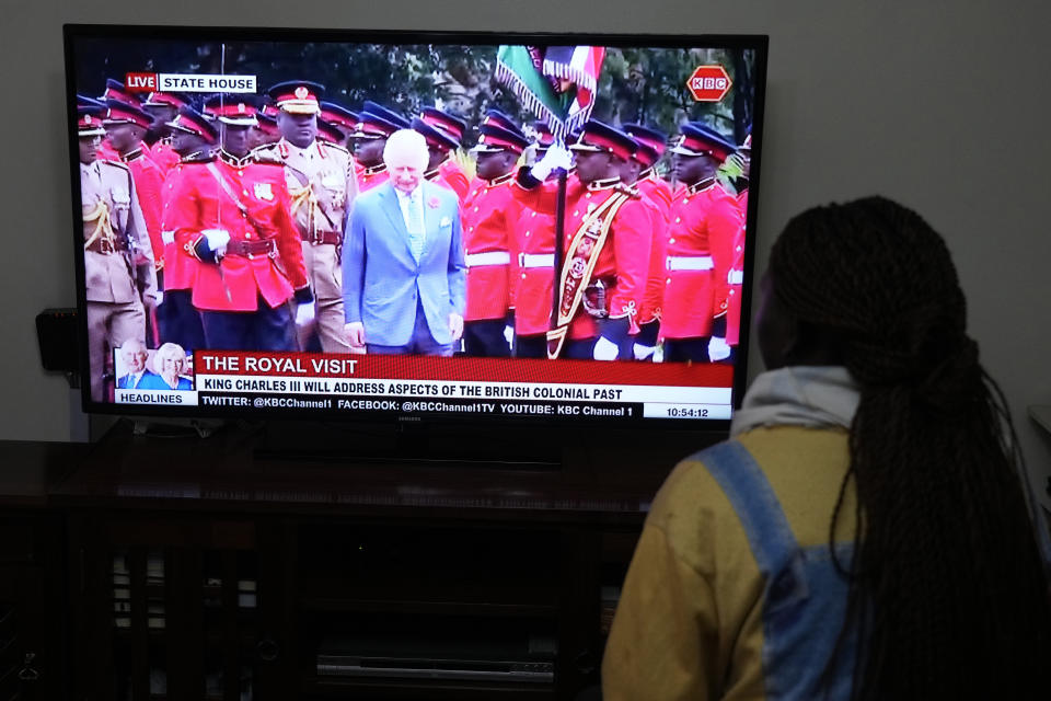 Una mujer keniata mira por televisión la cobertura en vivo de la visita del rey Carlos III en la Casa Estatal, en Nairobi, el martes 31 de octubre de 2023. (AP Foto/Sayyid Abdul Azim)