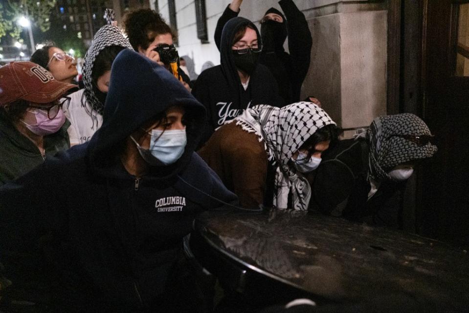 Protesters block the entrance to the school building after it’s taken over. AP