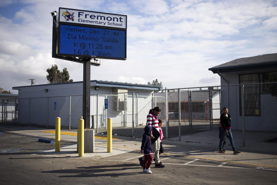 BAKERSFIELD, CA - DECEMBER 18, 2018: Nubia Estrada Umanzor, 34, holds hands with her children as they walk to Fremont Elementary School in Bakersfield, CA., on Monday, Dec. 18, 2018. (Jenna Schoenefeld for The Washington Post via Getty Images)