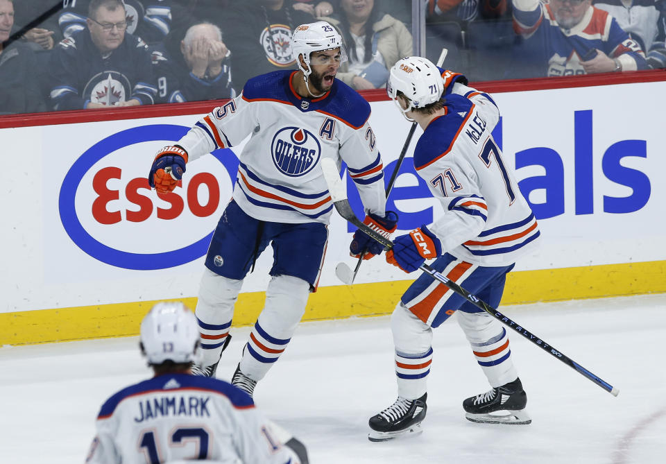 Edmonton Oilers' Darnell Nurse (25) and Ryan McLeod (71) celebrate Nurse's goal against the Winnipeg Jets during the third period of an NHL hockey game Thursday, Nov 30, 2023, in Winnipeg, Manitoba. (John Woods/The Canadian Press via AP)