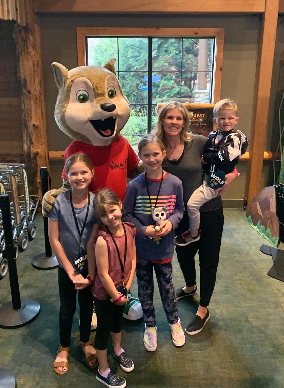 A mom and her 4 kids pose with a chipmunk character for a photo.