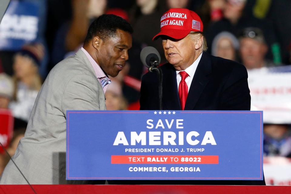 Former President Donald Trump shakes hands with Republican Senate candidate Herschel Walker at a ""Save America Rally" at the Banks County Dragway on Saturday, March 26, 2022.