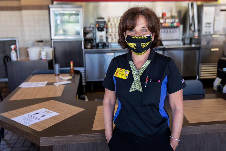 Ann Creel, a staff member of Waffle House poses for a portrait wearing a protective mask,  Waffle House is one of few corporate restaurant chain reopened for  in-house dining after a shutdown to prevent the spread of the coronavirus disease (COVID-19) in Madison, Georgia, U.S., April 27, 2020.  REUTERS/Maranie Staab