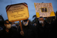 People attend a memorial march in homage to the history teacher who was beheaded last week, Tuesday, Oct.20, 2020 in Conflans-Sainte-Honorine, northwest of Paris. Samuel Paty was beheaded on Friday by an 18-year-old Moscow-born Chechen refugee, who was later shot dead by police. Police officials said Paty had discussed caricatures of Islam's Prophet Muhammad with his class, leading to threats. Placard at left reads: Teacher Samuel Paty's memory will not disappear, neither will freedom of speech. (AP Photo/Lewis Joly)