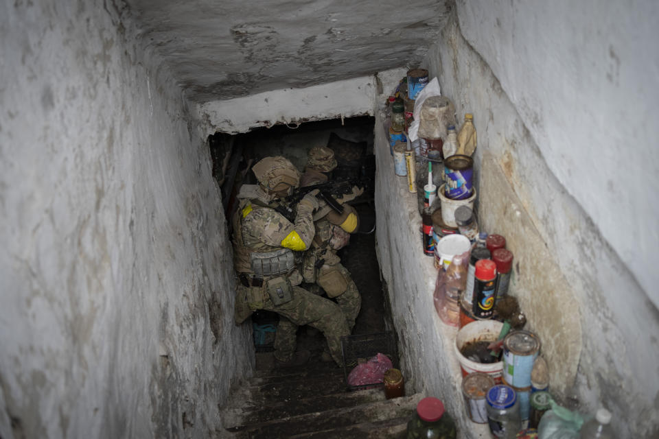 Soldados de la Guardia Nacional ucraniana inspeccionan un sótano durante una misión de reconocimiento el sábado 14 de mayo de 2022, en un pueblo recientemente recuperado en las afueras de Járkiv, al este de Ucrania. (AP Foto/Bernat Armangue)