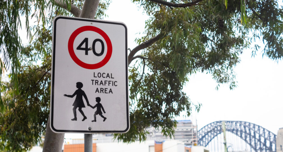 A 40km/h road sign in front of the Sydney Harbour Bridge. 