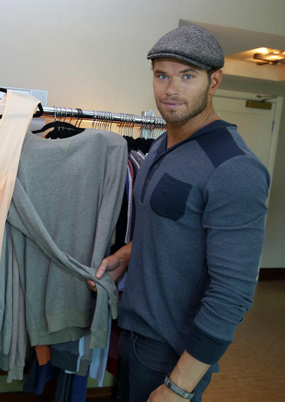 Actor and designer Kellan Lutz poses with selections from his pre-spring 2014 clothing line Abbot + Main at the Mandalay Bay Hotel on Monday, Aug. 19, 2013 in Las Vegas. (Photo by Isaac Brekken/Invision/AP)