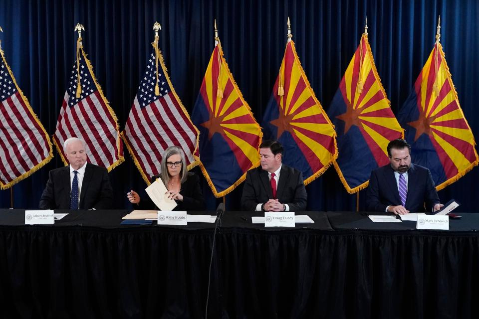 Katie Hobbs, the Democratic governor-elect and current secretary of state, second from left, signs the official certification for the Arizona general election canvass in a ceremony as Arizona Republican Gov. Doug Ducey, second from right, Arizona Supreme Court Chief Justice Robert Brutinel, left, and Arizona Attorney General Mark Brnovich flank Hobbs at the Arizona Capitol in Phoenix, Monday, Dec. 5, 2022.