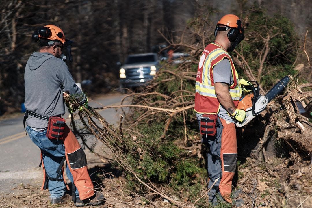 Volunteers from the nonprofit Team Rubicon conduct cleanup efforts in Mayfield, Kentucky, in December 2021 after a tornado ripped through the area. A Ford F-150 is seen in the background, as the company has been providing vehicles for disaster relief through its charitable Ford Fund, whose name is changing to Ford Philanthropy.