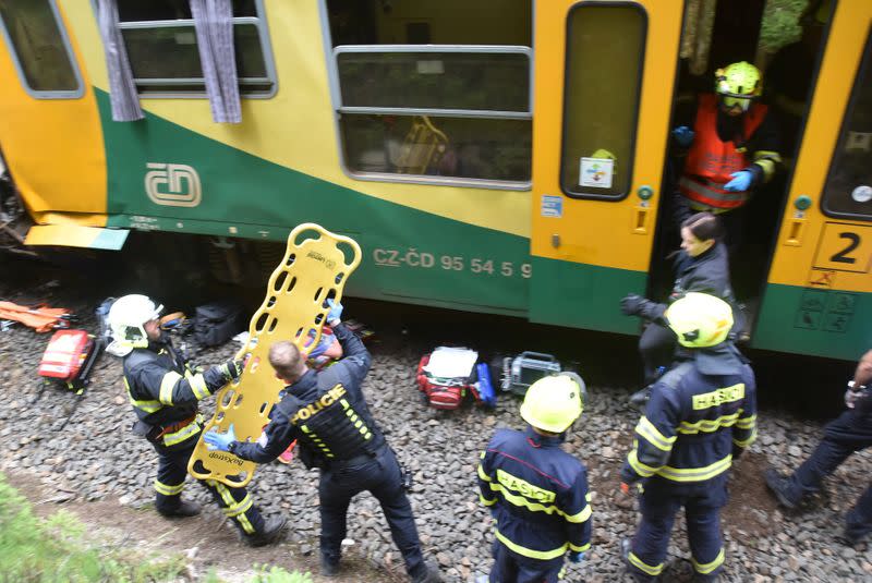 Firefighters are seen working on a site of a train crash near Pernink