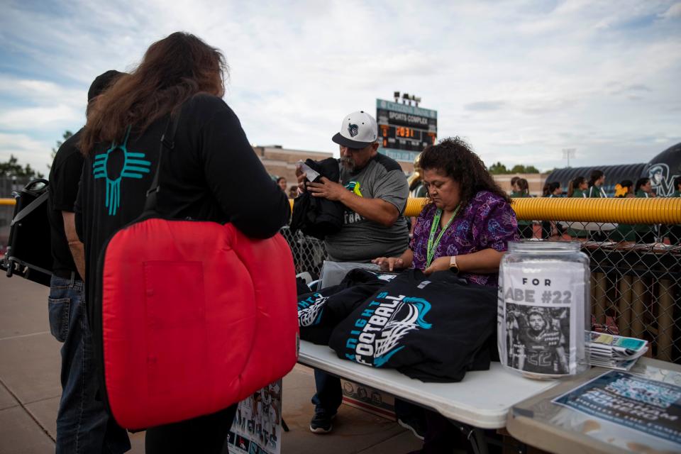 T-shirts and other memorabilia is sold to fundraise money for the Romero family during a high school football on Thursday, Sept. 1, 2022, at the Field of Dreams. Abraham Romero, the Organ Mountain High School football player who collapsed on the field last Friday night, remains in a medically induced coma.  