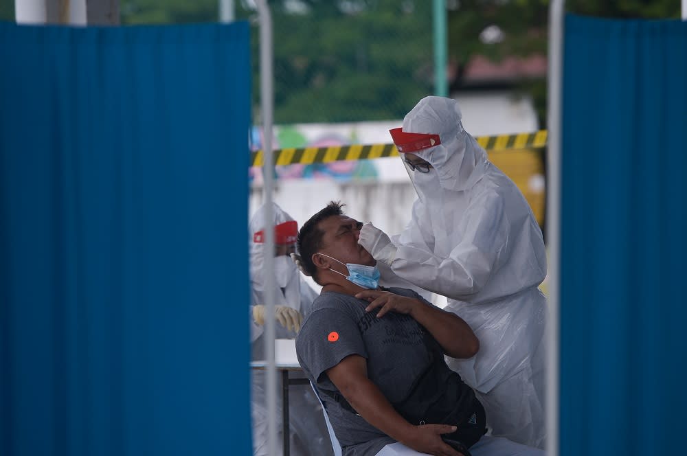 Healthcare workers collect swab samples to test for Covid-19 at the Selcare Clinic in Shah Alam June 24, 2021. — Picture by Miera Zulyana