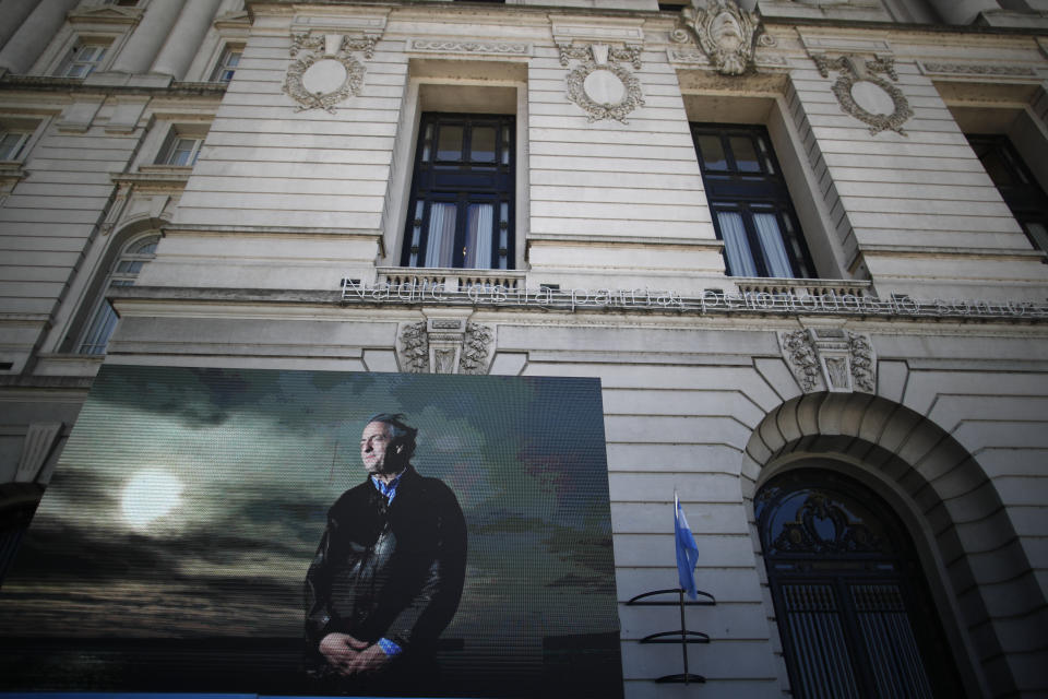 Una foto del difunto presidente Néstor Kirchner se muestra al final de un video afuera del Centro Cultural Néstor Kirchner donde se transmitió una ceremonia en vivo a personas afuera, para conmemorar el décimo aniversario de su muerte en Buenos Aires, Argentina, el martes 27 de octubre de 2020. (AP Foto/Natacha Pisarenko)